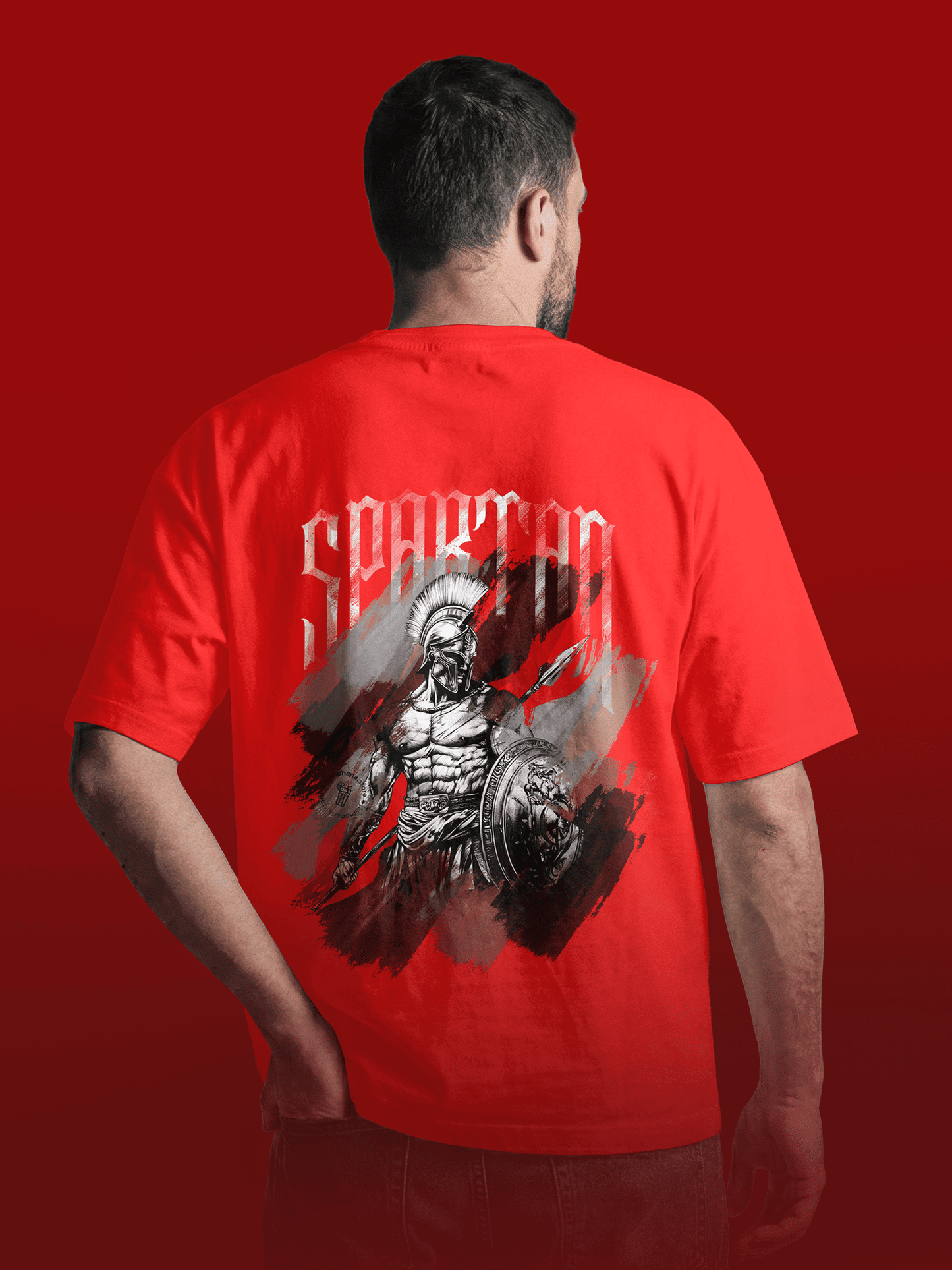 Person wearing a red t-shirt with a graphic design on the back against a red background