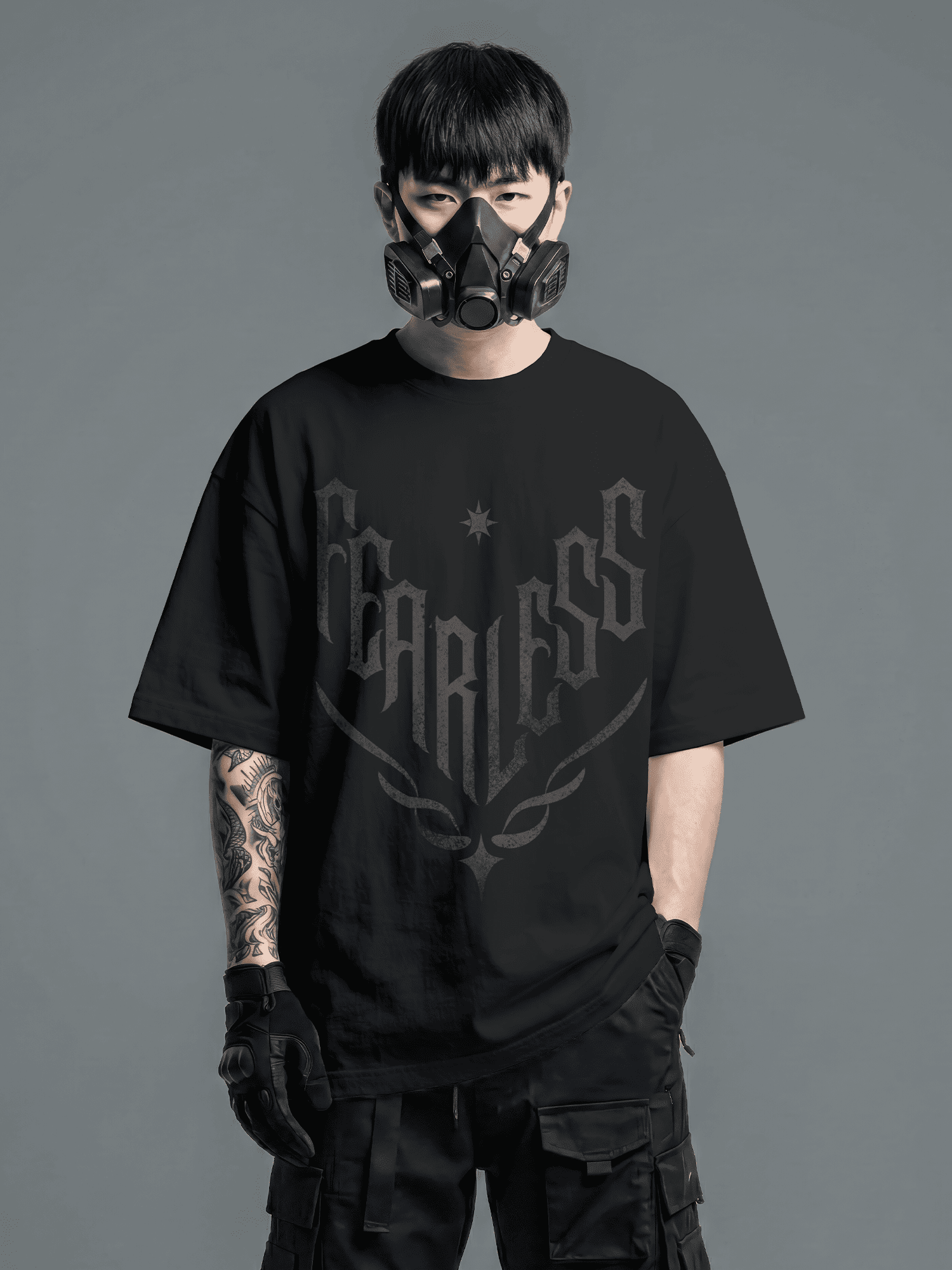 Person wearing a black 'Fearless' t-shirt with a gas mask on a gray background