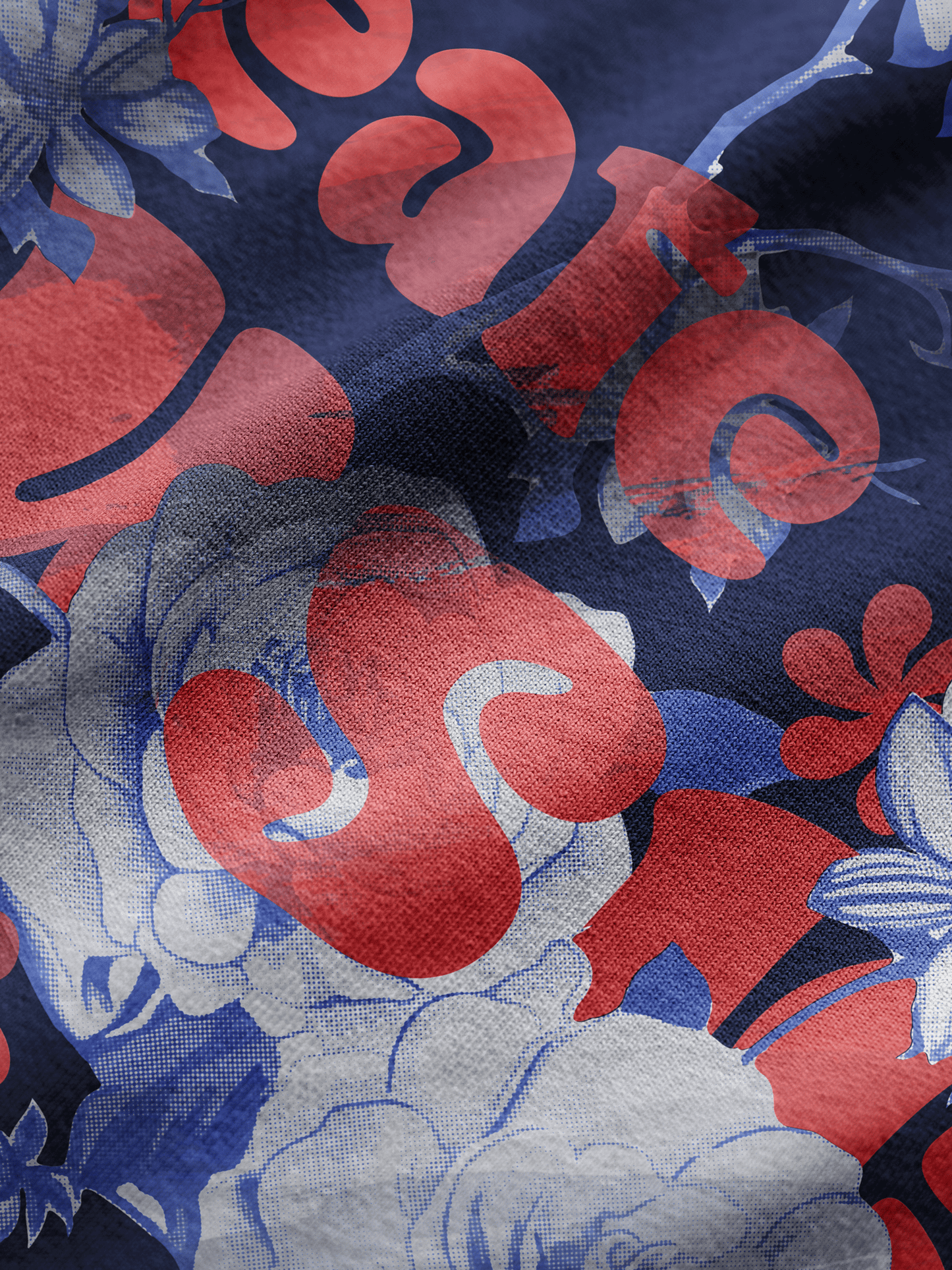 Close-up of fabric with red, blue, and gray floral pattern on a dark background