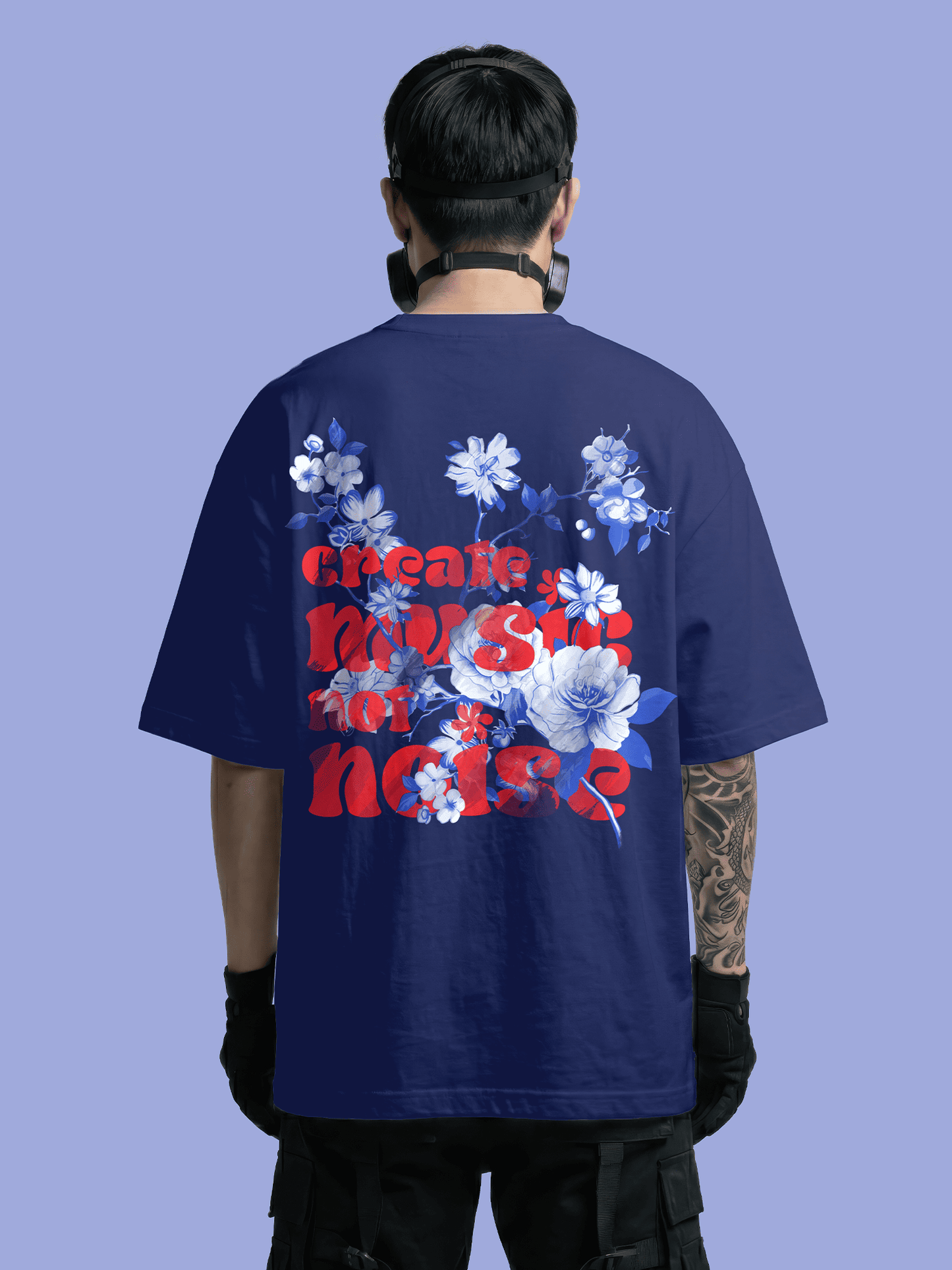 Person wearing a navy blue t-shirt with floral designs and text on the back against a solid background