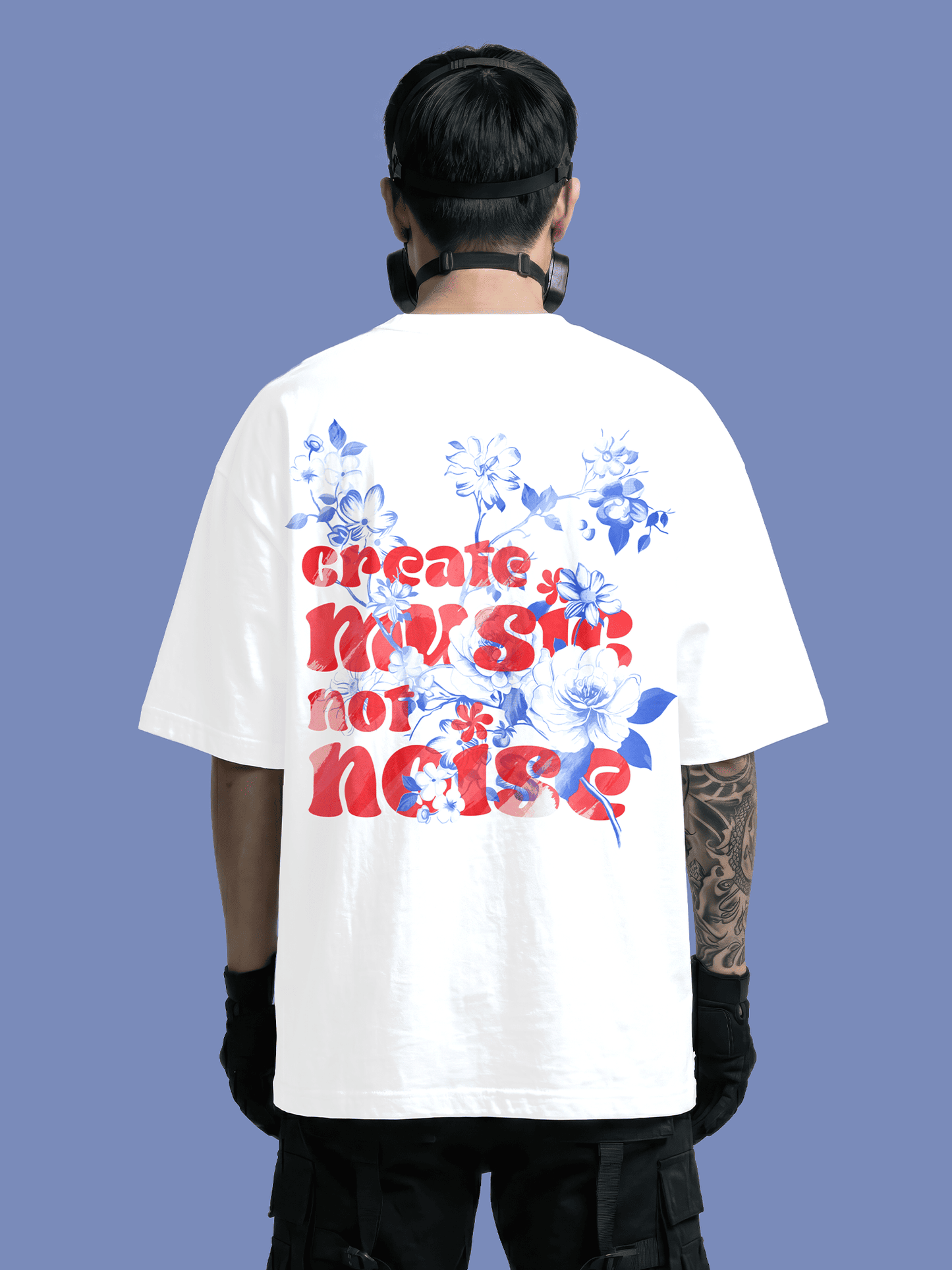Person wearing a white t-shirt with colorful text and floral designs on the back against a blue background