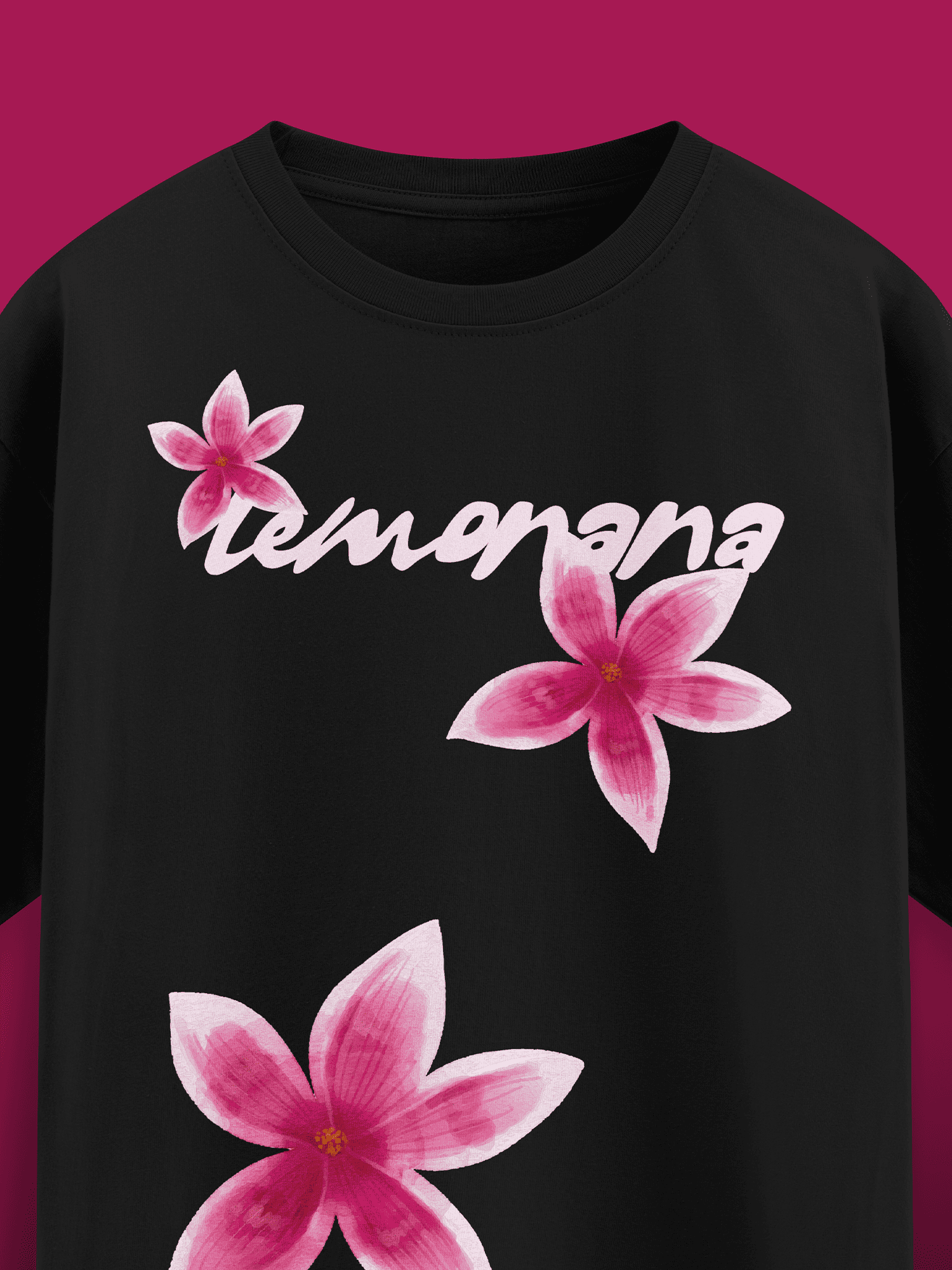 Black t-shirt with pink floral designs and 'tumamana' text on a magenta background