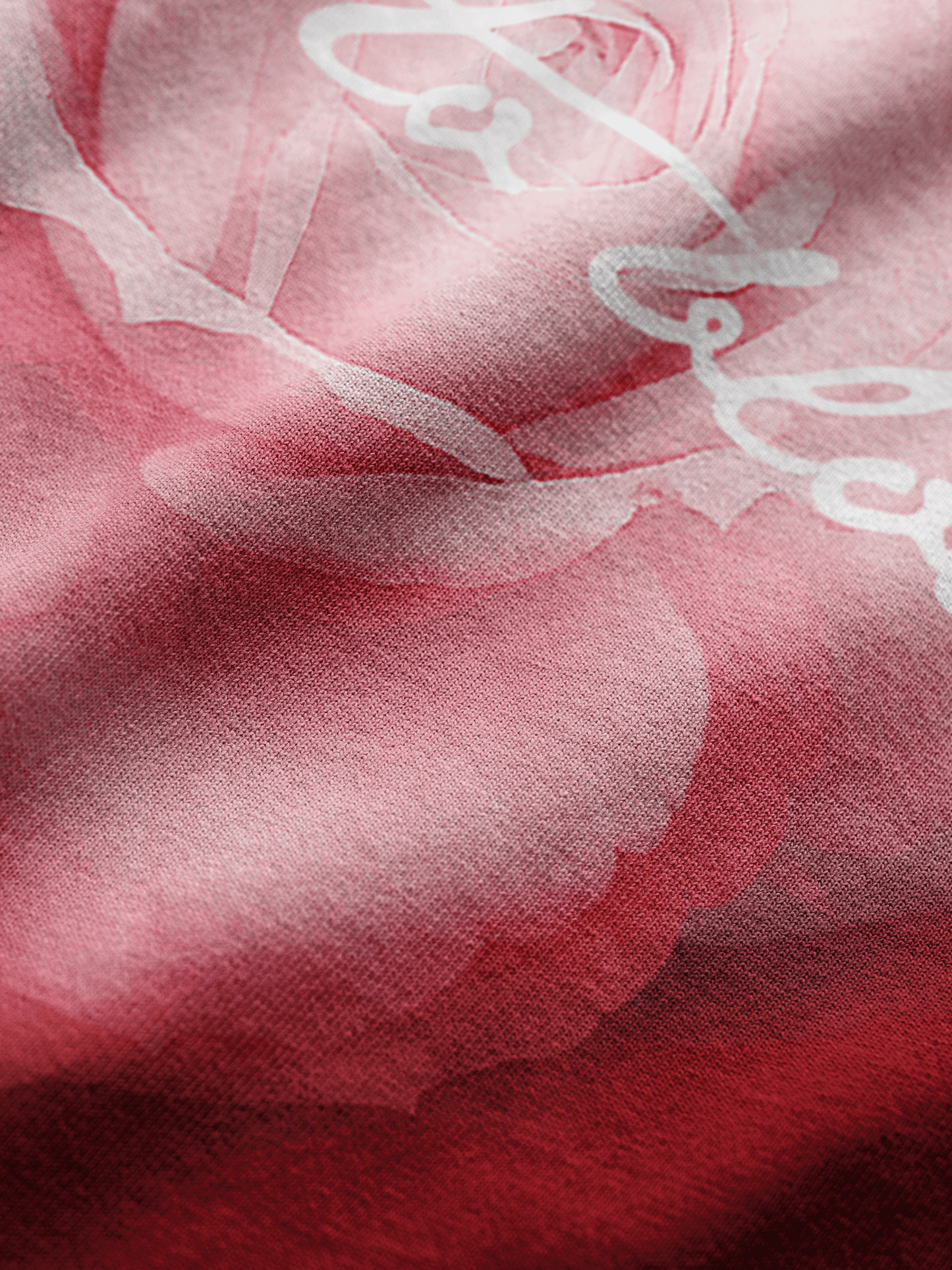 Close-up of a red and pink fabric with white text.