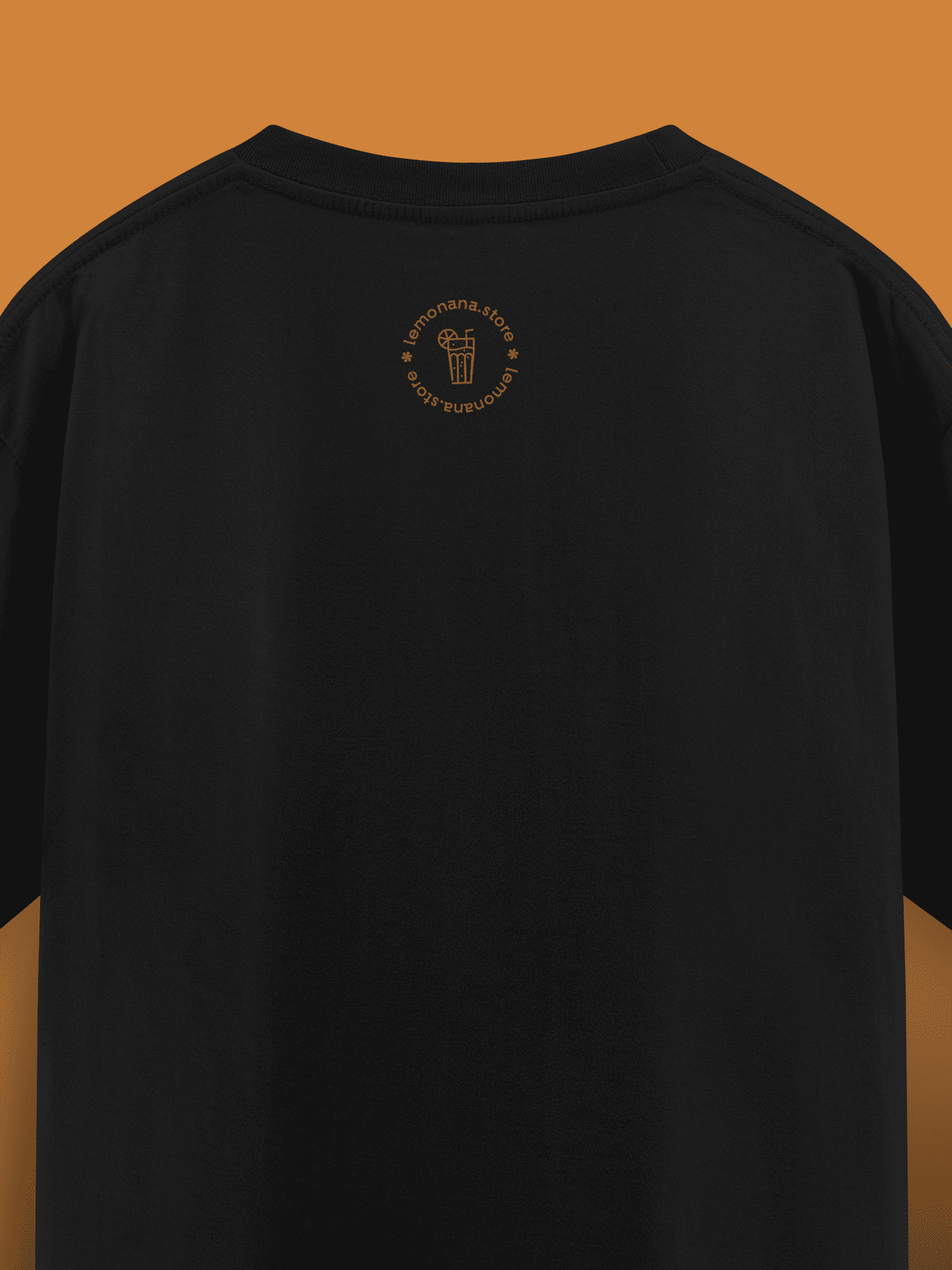 Black t-shirt with a small logo on the chest against a brown background
