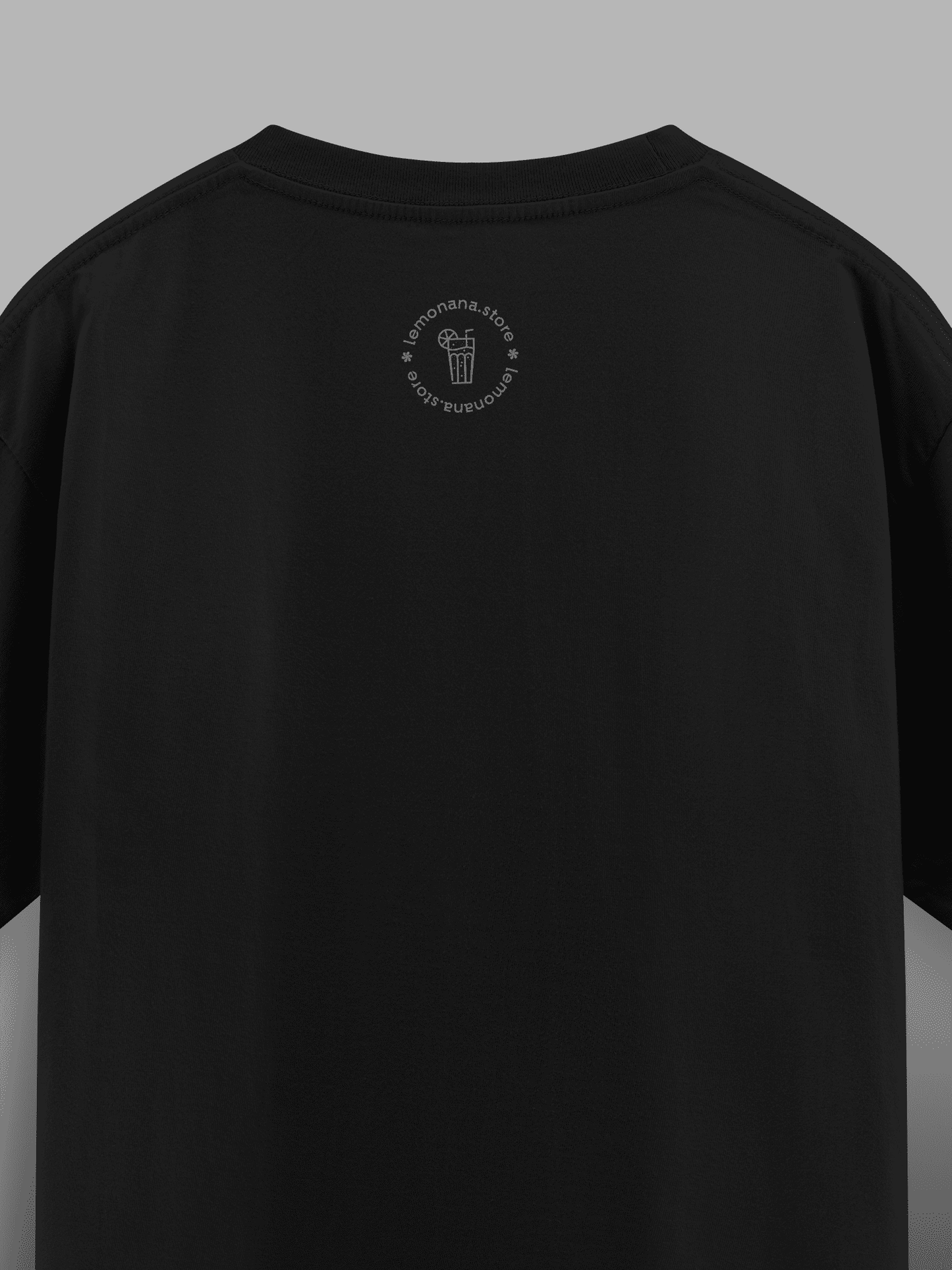Black t-shirt with a small logo on the back against a gray background